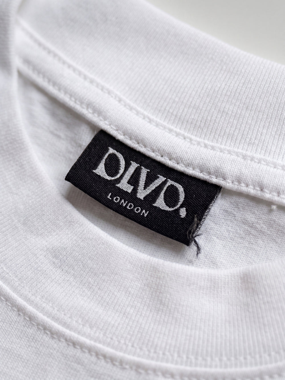White DLVD Classic tee side view on model